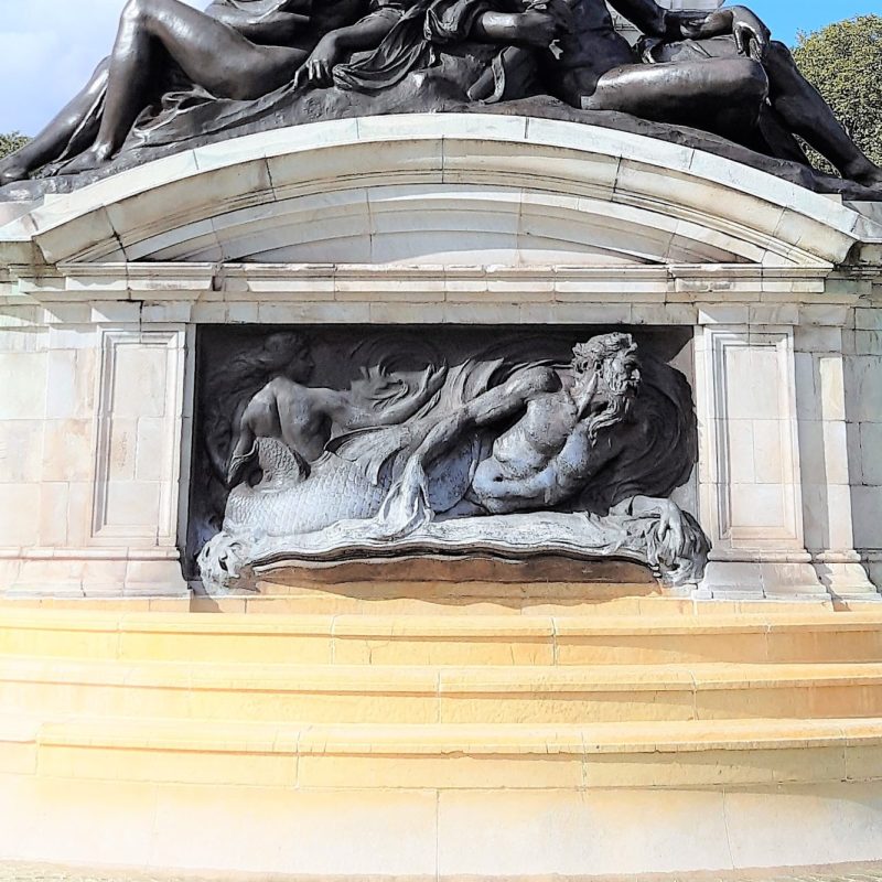 a statue of a person lying on top of a building