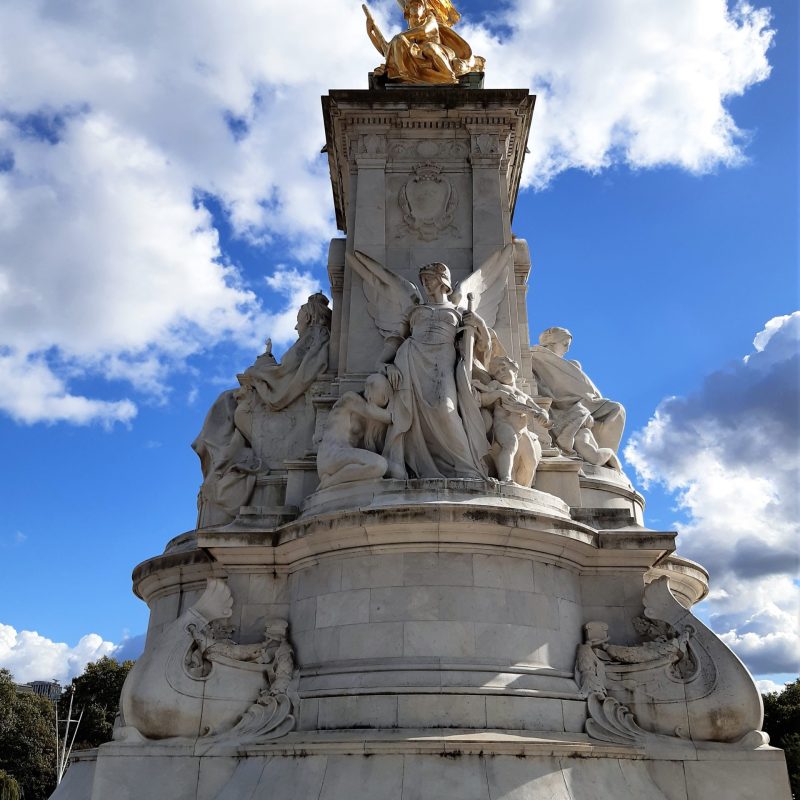 a large stone statue in front of Victoria Memorial, London