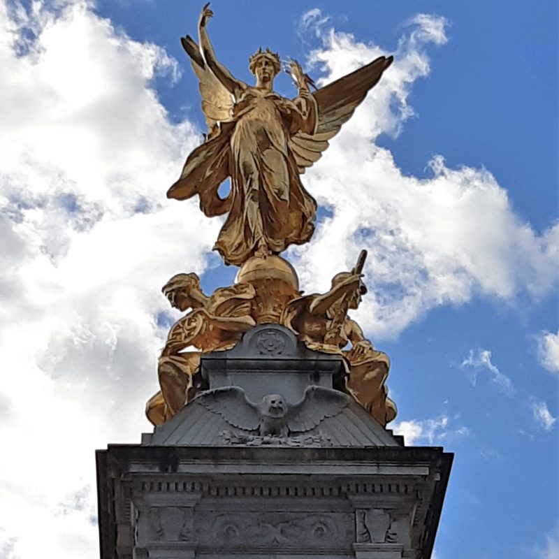 a clock tower in front of a statue